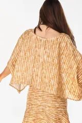 Blusa de lino italiano color blanco, con diseño holgado, escote asimétrico estilo off-shoulder y mangas cortas amplias.