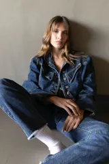 Pantalón de jean azul oscuro, de corte recto y tiro medio, con detalle de ruedo desflecado.