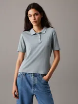 Chomba de manga corta, corte slim, color celeste claro con textura jaspeada. Presenta cuello de chomba y tapeta de tres botones. Posee un pequeño bordado en el pecho.