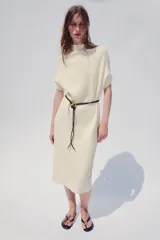 Vestido midi de punto color azul marino, de corte holgado, con cuello subido y manga corta vuelta. Incluye un cinturón fino efecto piel con hebilla metálica dorada.