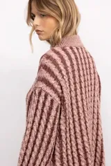 Sweater de tejido de punto con diseño de trenzas verticales, cuello alto, manga larga y silueta oversize de largo extendido.