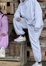 Pantalón deportivo de corte holgado en color gris melange, con cintura elástica, puños ajustados en los tobillos y bolsillos laterales.