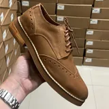 Zapato de vestir acordonado color marrón, de cuero con detalles de perforaciones decorativas.