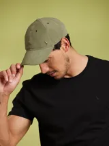 Gorro de béisbol color verde oliva, con logo metálico de un pájaro en el frente.