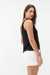 Musculosa bordó de tejido satinado, con escote en V y breteles con detalle de nudos en los hombros.