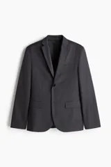 Blazer gris oscuro de corte slim fit, con solapas de muesca finas, ojal decorativo, botonadura sencilla, bolsillo superior insertado, bolsillos delanteros con solapa, dos bolsillos interiores, botones decorativos en los puños y abertura doble atrás.