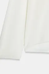 Jersey de punto fino negro con escote en V pronunciado, mangas largas y corte holgado con bajo asimétrico, más largo en la parte trasera.