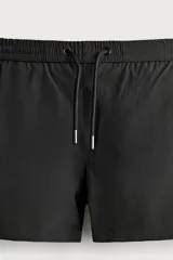 Short de baño negro de tejido técnico con estructura ripstop resistente a desgarros, cintura ajustable con cordón y bolsillos laterales.