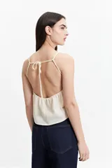 Musculosa de tiras finas color crema, con escote en V y vuelo en la base.