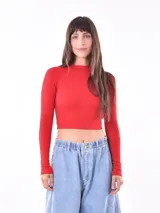 Remera crop de manga larga y cuello redondo, confeccionada en tejido de punto acanalado de color rojo.