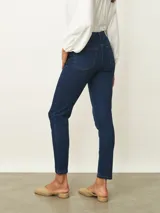 Jean de corte skinny en color azul medio, con tiro medio, cierre frontal con botón y bolsillos laterales y traseros.