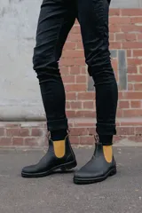 Botas Chelsea de cuero marrón con elástico lateral color mostaza, suela de goma negra y tirador trasero.