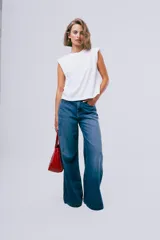 Jean de denim azul de corte wide leg, tiro medio y diseño holgado de pernera ancha.