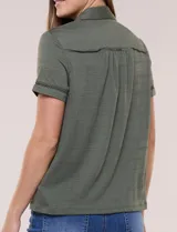 Camisa de manga corta color marrón oscuro, con cuello camisero, alforzas verticales, detalles de puntilla calada y frunces bajo el busto. Cuenta con cierre frontal de botones.