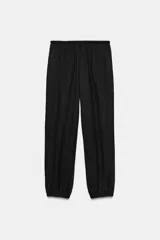 Pantalón bombacho de tiro medio color vino, con cintura ajustable mediante cordón y puños elásticos ajustables con botón en los tobillos.