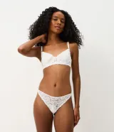 Kit de dos bombachas bikini Lov confeccionadas en encaje floral con leve transparencia, una en color negro y otra en color blanco. Cuentan con un diseño cómodo y un pequeño lazo decorativo con dije metálico en la parte delantera.
