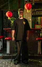 Remera negra de algodón con corte holgado y estampado frontal de un demonio con cuernos en color amarillo.