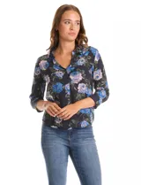 Camisa de gasa con estampado floral en tonos azules y rosados sobre fondo negro. Presenta cuello con solapa, escote en V, cierre frontal con botones y mangas tres cuartos con puños abotonados.
