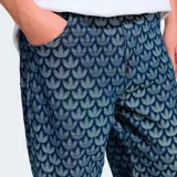 Pantalón Adidas Originals de corte holgado (baggy fit) con estampado integral de monograma del logo Trefoil. Confeccionado en tejido denim, presenta un diseño de pierna ancha y tiro medio.