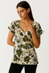 Blusa de viscosa con estampado floral en tonos verde militar, verde claro, gris y negro sobre fondo blanco. Presenta cuello en V y mangas cortas con volados.