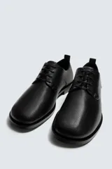 Zapato de vestir tipo derby, color negro, fabricado en piel con horma cuadrada y suela con ligero tacón.