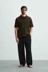 Polo de tejido canalé en color blanco, con cuello solapa y abertura frontal en V, de manga corta y corte regular.