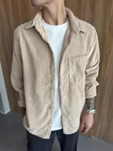 Sobrecamisa de pana color beige, con cuello clásico, cierre frontal de botones y un bolsillo en el pecho.
