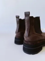 Bota Chelsea de cuero color marrón chocolate con elástico lateral negro y suela track color negro.