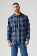 Camisa de manga larga azul a cuadros, con cuello clásico, cierre frontal con botones, dos bolsillos con solapa abotonada en el pecho y corte recto.