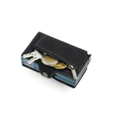 Billetera compacta de cuero negro con costuras contrastantes en azul claro. Presenta un mecanismo de apertura lateral y un detalle en la parte inferior que funciona como abridor de botellas. El nombre de la marca "BALEINE" está grabado en la parte inferior frontal.