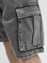 Bermuda cargo de jean de tiro alto, corte baggy fit y pernera amplia. Cuenta con múltiples bolsillos, incluyendo bolsillos cargo laterales, traseros, delanteros y para monedas, con cierre de botones y acabado stonewash efecto desgastado.
