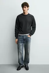 Mocasín de cuero negro con antifaz en el empeine y suela a tono con ligero tacón.