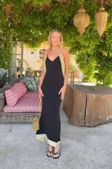 Vestido largo negro Lady Pipa con tirantes finos, escote en V y detalles en tejido dorado brillante en los laterales y el bajo.