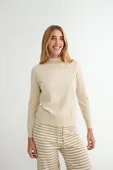 Polera de punto color beige, con cuello alto y mangas largas, de diseño básico y ajuste clásico.
