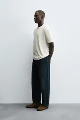 Camiseta de manga corta y cuello redondo, color blanco roto, con textura seersucker.