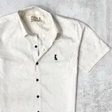 Camisa de manga corta color beige jaspeada con cuello común y cierre con botones.