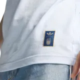 Remera de fútbol Adidas de la selección de Italia, de color celeste con cuello redondo y detalles en azul marino en el cuello y las mangas. Presenta el logotipo de Adidas Originals y el escudo de la Federación Italiana de Fútbol bordados en el pecho, junto con las clásicas tres tiras de la marca sobre los hombros.