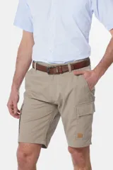 Bermuda cargo color beige con bolsillos laterales y traseros. Se ajusta a la cintura con cinturón de cuero marrón.