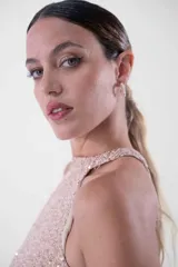 Vestido largo con cuello halter enteramente cubierto de lentejuelas, que combina un cuerpo superior en tono rosado y una falda larga en color negro.
