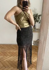 Falda tejida a mano en crochet, color crudo, con flecos en el ruedo y abertura lateral.