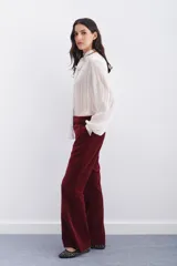 Pantalon estilo oxford confeccionado en terciopelo azul marino, con corte de tiro medio, bolsillos laterales diagonales y cierre frontal oculto.