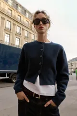 Chaqueta de punto de cuello redondo y manga larga, con cierre frontal de botones y acabados en rib.