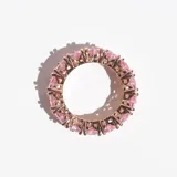 Anillo de acero con acabado en oro rosa, con cristales rosas en forma de corazón engarzados en diseño infinito.