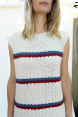 Vestido midi tejido en hilo de algodón, sin mangas y con escote redondo. Presenta un diseño de rayas horizontales en tonos beige, azul y rojo.