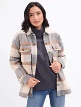 Sobrecamisa de franela con diseño a cuadros en tonos beige, gris y marrón. Presenta cuello clásico, cierre frontal con botones, bolsillos delanteros con solapa y mangas largas con puños abotonados.