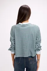 Remera de manga larga con diseño de rayas horizontales en color rojo y rosado, cuello redondo y puños elásticos en color rosado.