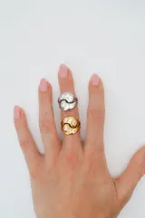 Anillo plateado de acero quirúrgico con diseño entrelazado y circonias incrustadas.