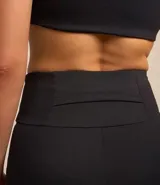 Bermuda deportiva negra con detalles en rosa y blanco en los laterales, confeccionada en poliamida y elastano, de cintura alta y calce ajustado.