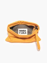 Bolso bandolera de nylon color azafrán. Modelo de tamaño mini con cierre de cremallera, bolsillo interior plano y asa de cadena plateada. Exterior personalizado con Logo Chimo.