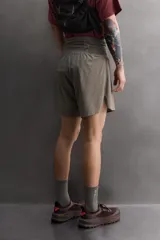 Short deportivo de trail running confeccionado en tejido técnico elástico con textura. Presenta una cintura elástica ancha con compartimentos integrados, bolsillo trasero con cierre y aberturas laterales en el bajo.